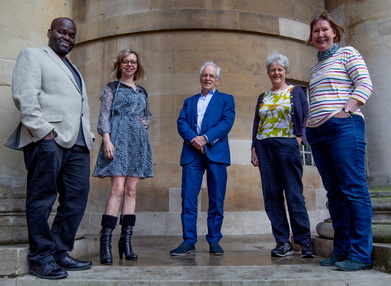 A group of people standing in front of a wall

Description automatically generated with medium confidence